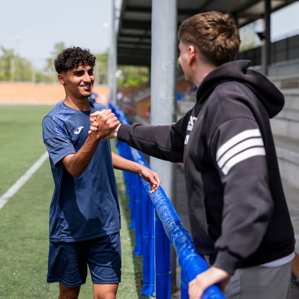 NXT footballer shaking hand with coach